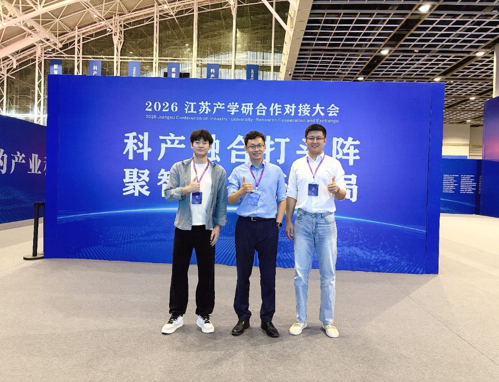 2026 江苏产学研合作对接大会主背景板前的聚思睿参展团队